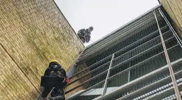 man abseiling down building